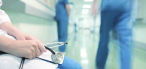 Doctor sitting in hospital corridor on the background of colleag